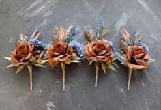 three boutonnieres with dried flowers on them