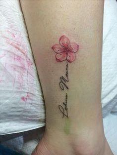 a woman's foot with a pink flower on it and the word love written in cursive writing