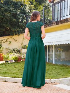 a woman in a green dress standing outside