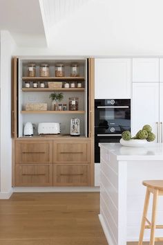 a kitchen with white cabinets and wooden floors