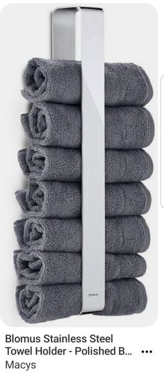 a stack of gray towels sitting on top of a white towel rack