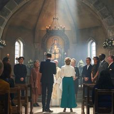 a man and woman are standing in front of the alter at a church with other people