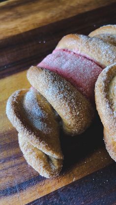 powdered sugar donuts on a wooden cutting board