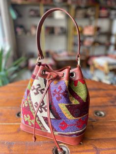 a colorful purse sitting on top of a wooden table