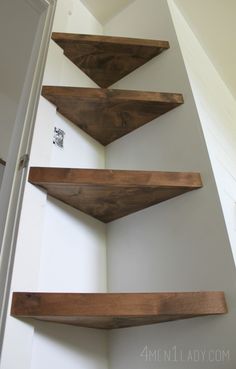 three wooden shelves on the wall in a room