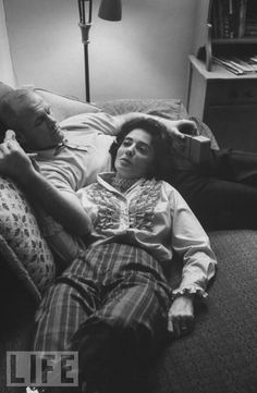 a man and woman laying on the floor next to each other in a living room