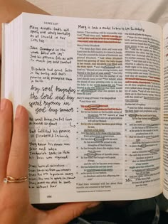 a person holding an open book with writing on the pages and in front of them