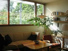 a living room filled with furniture next to a window covered in blindes and blinds