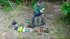 a man sitting on the ground with many items around him