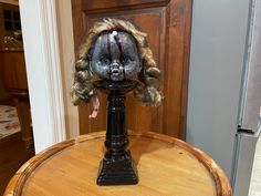 a creepy doll head sitting on top of a wooden table