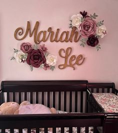 there is a crib with flowers on the wall