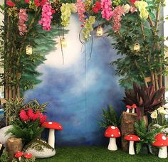 an outdoor area with flowers and mushrooms on the grass, surrounded by fake trees and plants