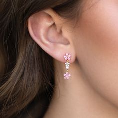 a close up of a woman's ear with pink flowers on it