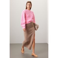 a woman in a pink sweater and brown skirt