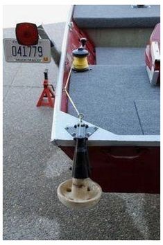 a red and white boat sitting on top of a cement floor next to a sign