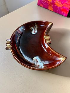 two brown and white dishes sitting on top of a table