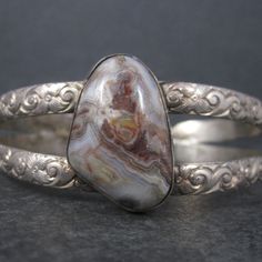 This gorgeous vintage cuff bracelet is 900 silver with an 19x28mm agate stone. The face of this bracelet measures 1 3/16 inches. It has an inner circumference of 7 inches including the 1 inch gap.  Weight: 36 grams Marks: none - acid tested Condition: Excellent Vintage Cuff Bracelet, Agate Stone, Cuff Bracelet, Cuff Bracelets, The Face, 1 Inch, Agate, Jewelry Bracelets, Gap