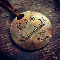 a metal disc with writing on it sitting on top of a wooden table next to a string