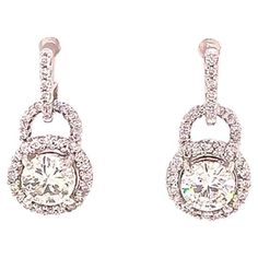 Beautiful Diamond halo drop dangling earrings in 18k white gold. These gorgeous earrings feature two round brilliant cut diamonds at the center, each measuring approximately 5.80 mm x 5.80 mm x 3.45 mm with the approximate carat weight of 0.70 ct. each. The center diamonds are H in color and SI1 - SI2 in clarity and totaling approximately 1.40 carats. The center diamonds are set in four prongs and surrounded by pave' set diamond halos. The halos are attached to an horse shoe design also pave' se Gia Certified Drop Diamond Earrings For Formal Occasions, Diamond White Platinum Dangle Earrings, Formal Gia Certified Dangle Diamond Earrings, Platinum Diamond Dangle Earrings With Prong Setting, Platinum Dangle Diamond Earrings With Prong Setting, Gia Certified Dangle Earrings For Formal Events, Gia Certified Dangle Earrings For Formal Occasions, Platinum Diamond Dangle Earrings In White Gold, Platinum Dangle Diamond Earrings