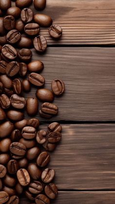 coffee beans are scattered on top of a wooden table with space for text or image