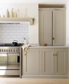 a kitchen with an oven, stove and cupboards in white painted wood paneling