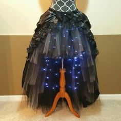 a mannequin dressed in black and white with blue lights on it's skirt