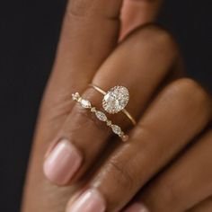 a woman's hand holding an engagement ring with two diamonds on the top and bottom