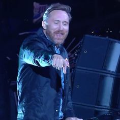 a man in a black jacket and tie holding a keyboard