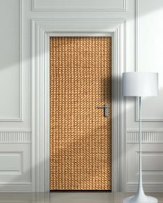 the door is made out of straw and has a lamp on it next to it