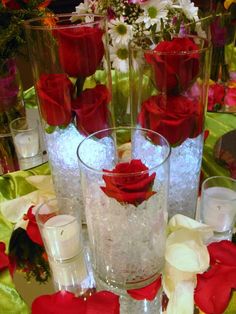 there are many vases with roses in them on the table