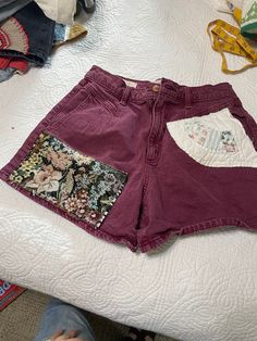 One of a Kind patched shorts, made with high waisted maroon shorts and 3 different vintage patches. Hand pieced quilts, old upholstry fabric, and a vintage quilt piece all add to these shorts and make them unforgettable. Patched Shorts, Upholstry Fabric, Hand Pieced Quilts, Patched Denim, Maroon Shorts, Pieced Quilts, Vintage Patches, Vintage Quilt, Denim Patches