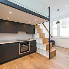 an open kitchen and living room with stairs