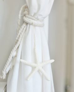 a white curtain with a starfish tied to it