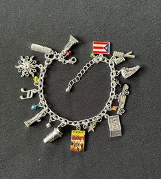 a bracelet with various charms on it sitting on top of a gray surface, in the shape of an american flag