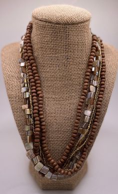 Beautiful bohemian multi strand necklace. Very earthy with wooden and shell beads. Extra links on clasp to adjust length. Bohemian style is more than just a fashion trend. It's an actual culture in its own right, one that comes with a very specific ideology and complicated history. While it's closely associated with the hippie fashions of the 60s and 70s, these days, bohemian fashion is part of the mainstream culture. But fact is, boho fashion actually started out as a counterculture back in the Bohemian Brown Shell Necklace With Wooden Beads, Bohemian Brown Double Strand Necklace, Bohemian Multi-strand Wooden Beaded Necklaces, Bohemian Multi-strand Beaded Necklaces With Wooden Beads, Bohemian Multi-strand Beaded Necklace With Wooden Beads, Bohemian Brown Shell Necklace With Round Beads, Brown Multi-strand Wooden Beaded Necklaces, Brown Multi-strand Necklace With Colorful Beads, Brown Multi-strand Necklace With Large Beads