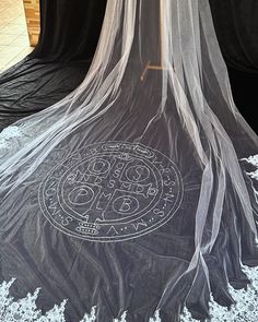 the veiled bed is covered with white lace and has an image of a circle on it