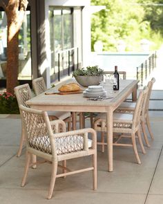 an outdoor dining table with chairs and a bowl of food on the outside patio area