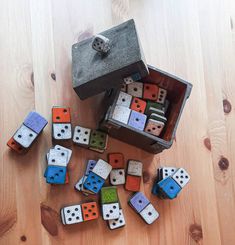 several different colored dices are on the floor next to a box and some scissors