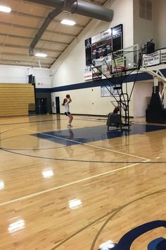 two people playing basketball in an indoor gym