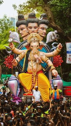 a large statue of the hindu god ganesh in front of a group of people