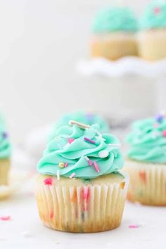 cupcakes with blue frosting and sprinkles on them are shown