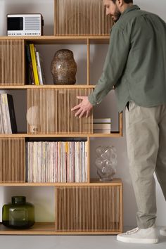 a man standing in front of a book shelf