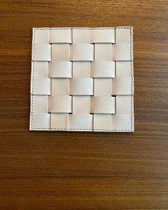 a white woven wallet sitting on top of a wooden table