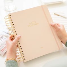 a person holding a pink planner in their hand