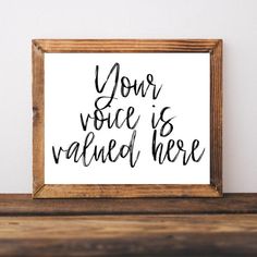 a wooden frame holding a black and white print with the words your voice is nailed here