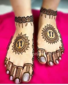 the feet and hands of a woman with henna tattoos