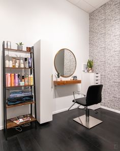 a hair salon with a chair, mirror and shelves