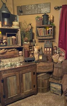 a room filled with lots of old wooden crates and other items on display next to a red curtain