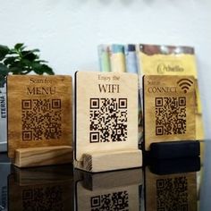 three wooden blocks sitting on top of a table next to each other with qr code printed on them