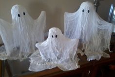 three white ghost decorations sitting on top of a table